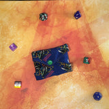 Folded reuseable liner with colorful dice on a textured orange surface