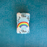 This pad has been folded into a bundle and closed with the snap, making a tidy little roll with the words "Fuck this Shit" and a rainbow centered clearly on it.